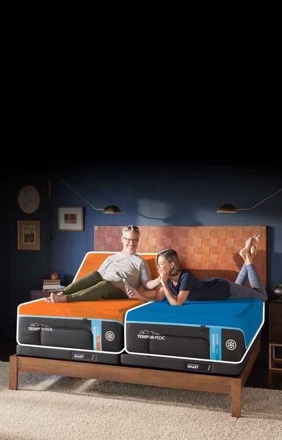 A couple laying on a split king mattress with a firm and soft feel - mobile view