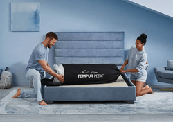 A joyous couple unbagging the Tempur-Cloud mattress-in-bag