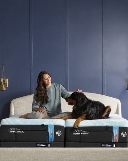 Woman and dog sitting on a Tempur Pedic breeze split king mattress