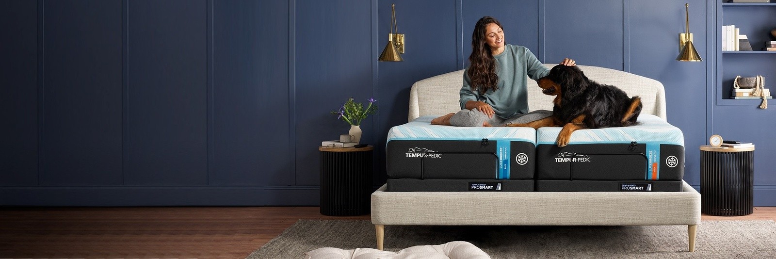 A woman laying on a Breeze mattress with her dog