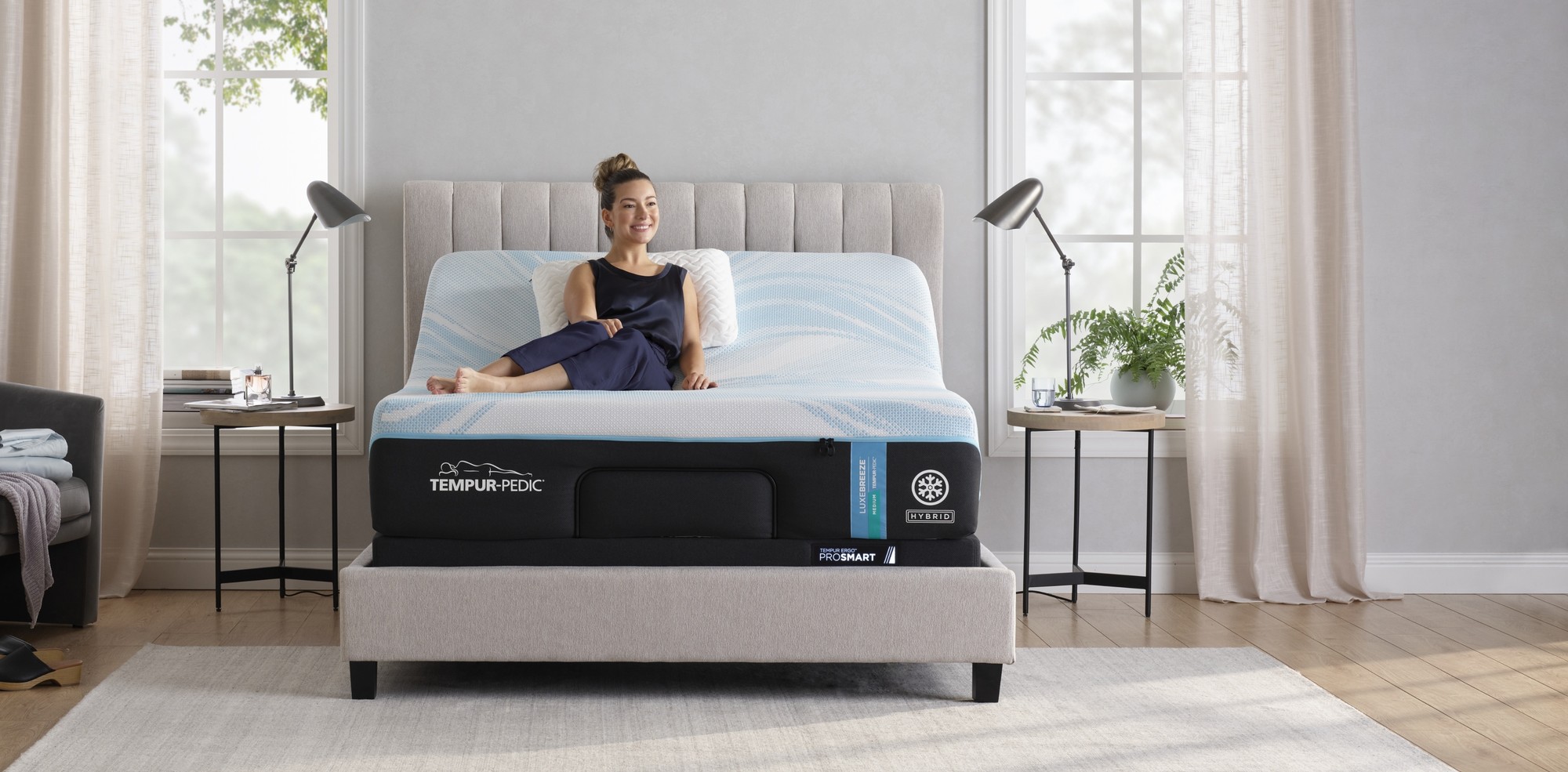 woman sitting on a tempur pedic breeze mattress and adjustable base